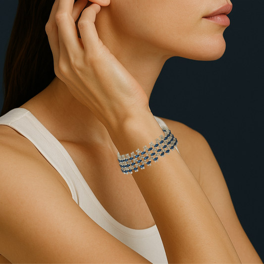 Handwoven bracelet with sapphire blue and clear crystal glass beads in a geometric openwork pattern, shown on a wrist