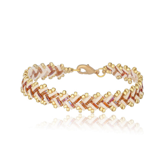 Bracelet with gold, pink, and ivory T pattern on a white background