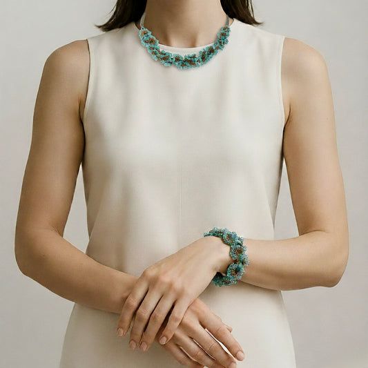 Woman wearing a white sleeveless dress with a green ondine beaded necklace and bracelet against a neutral background