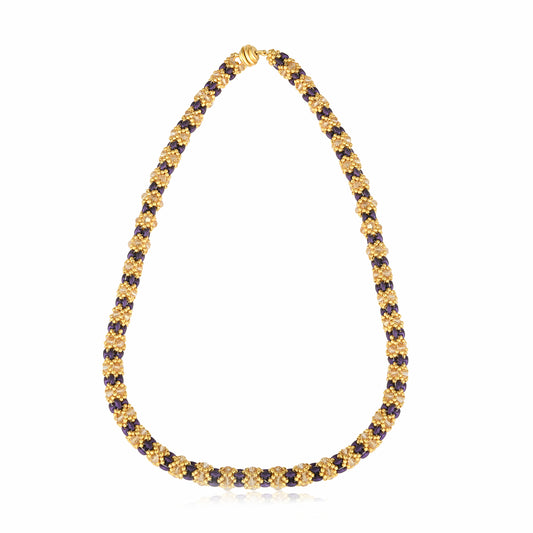 Handmade beaded necklace in gold and violet tones, floral pattern, on white background