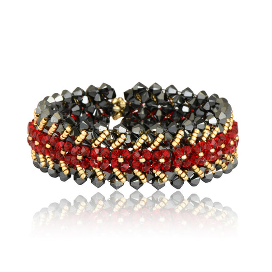 Bracelet handwoven with Swarovski crystal beads in garnet red, graphite grey, and soft gold. Geometric design with gold-tone clasp, shown on a white background.